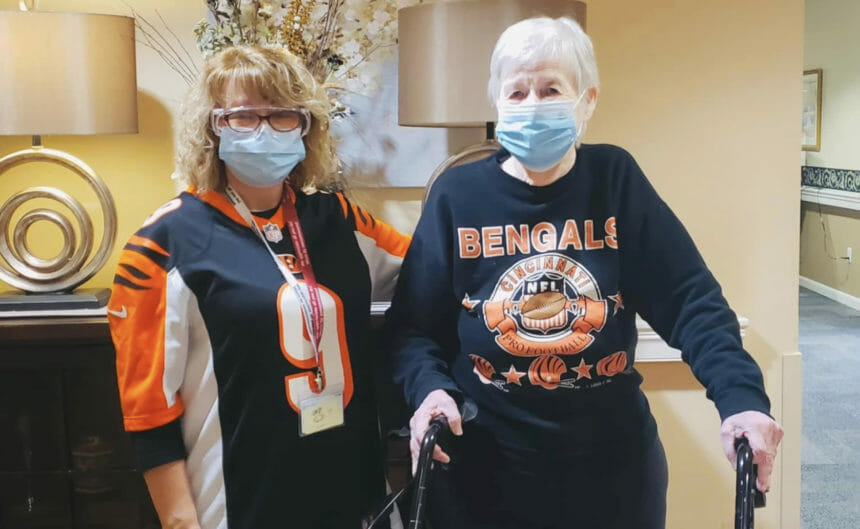 A Maple Knoll staffer and resident post for a photo while dress in Bengals apparel.
